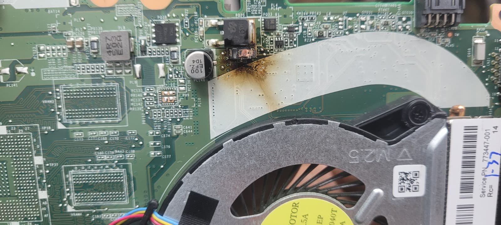 Laptop motherboard with corrosion and burn damage being repaired